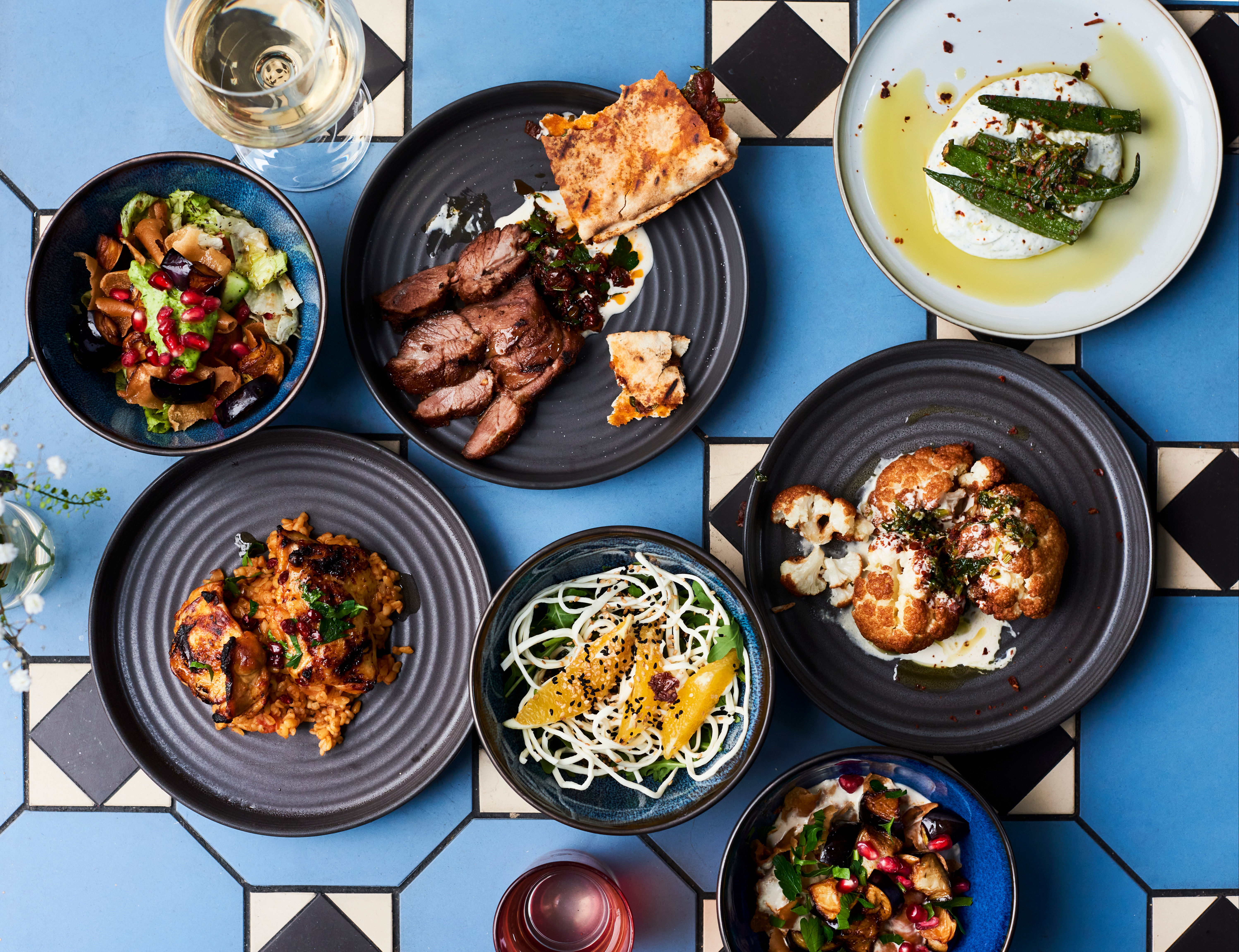 Clockwise from top left: fattoush baitinjan; Hamsit Lahem (lamb shoulder); Mtafayt Bamye; Zahrah Hara; za’atar salad; Jaj Mtafeieh (chicken thighs)